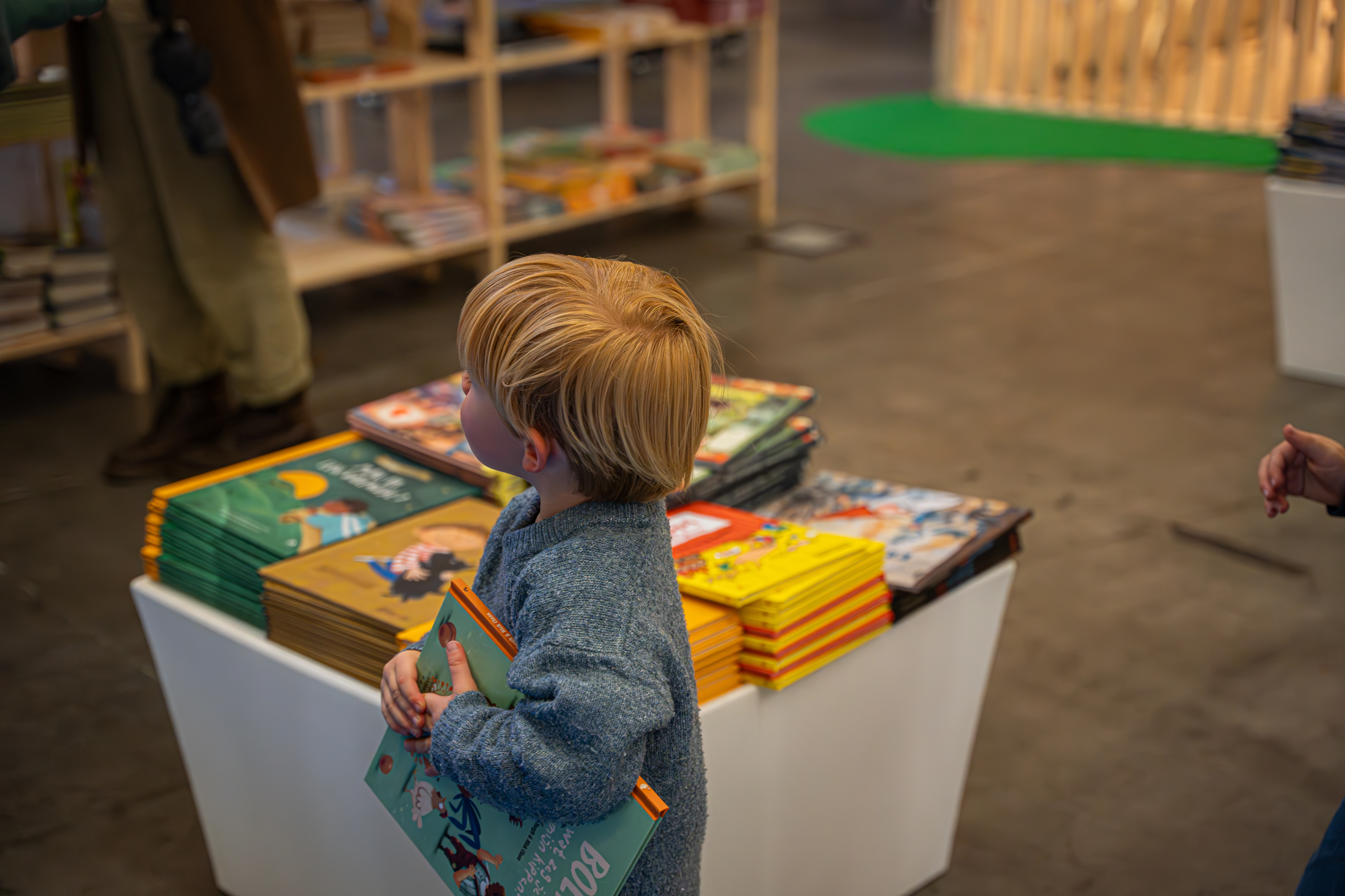 een blond jongentje met een boek in de hand